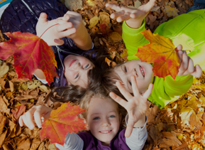 Kids laying in leafs